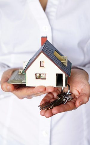 A vertical closeup shot of a person thinking of buying or selling a house